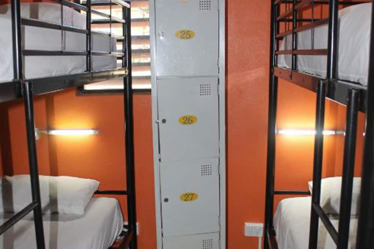 Un dormitorio con literas, un espacio de almacenamiento central y una ventana con vistas.