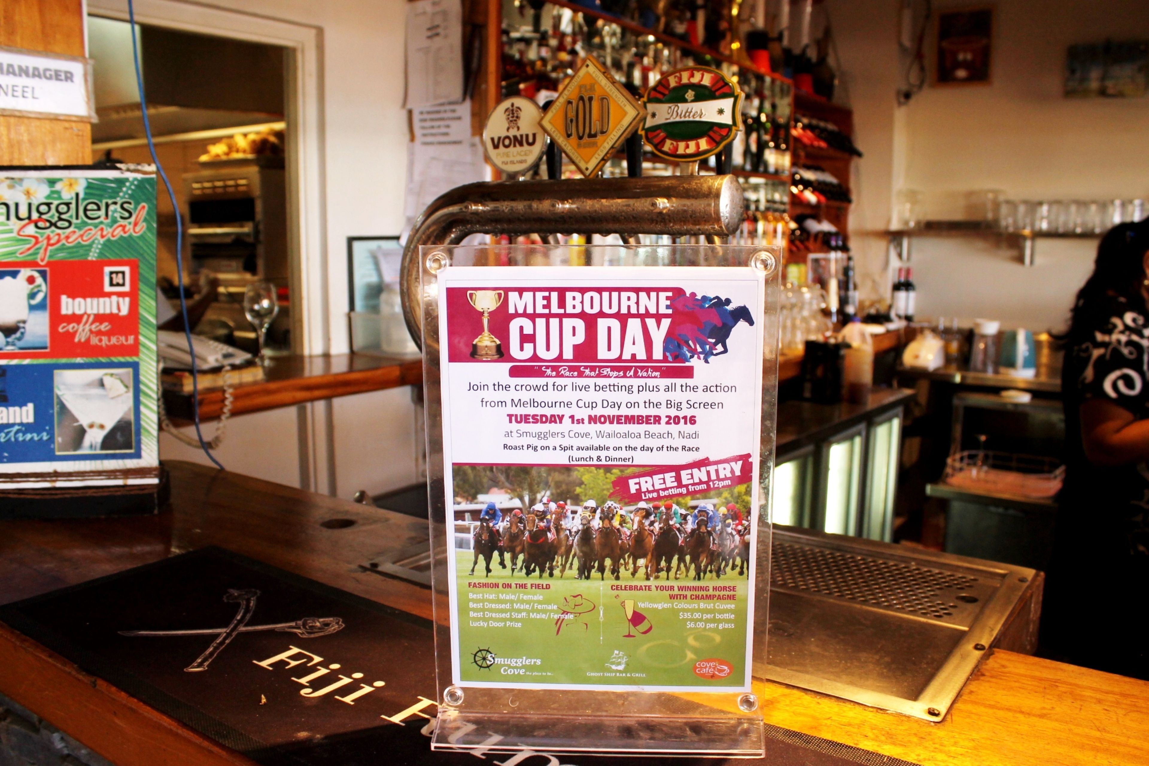 A bar counter with a sign for 'Melbourne Cup Day' and a 'Free Entry' offer.
