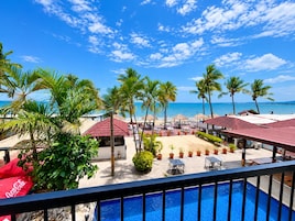 Un resort con piscina, zona de estar al aire libre y vista al mar.