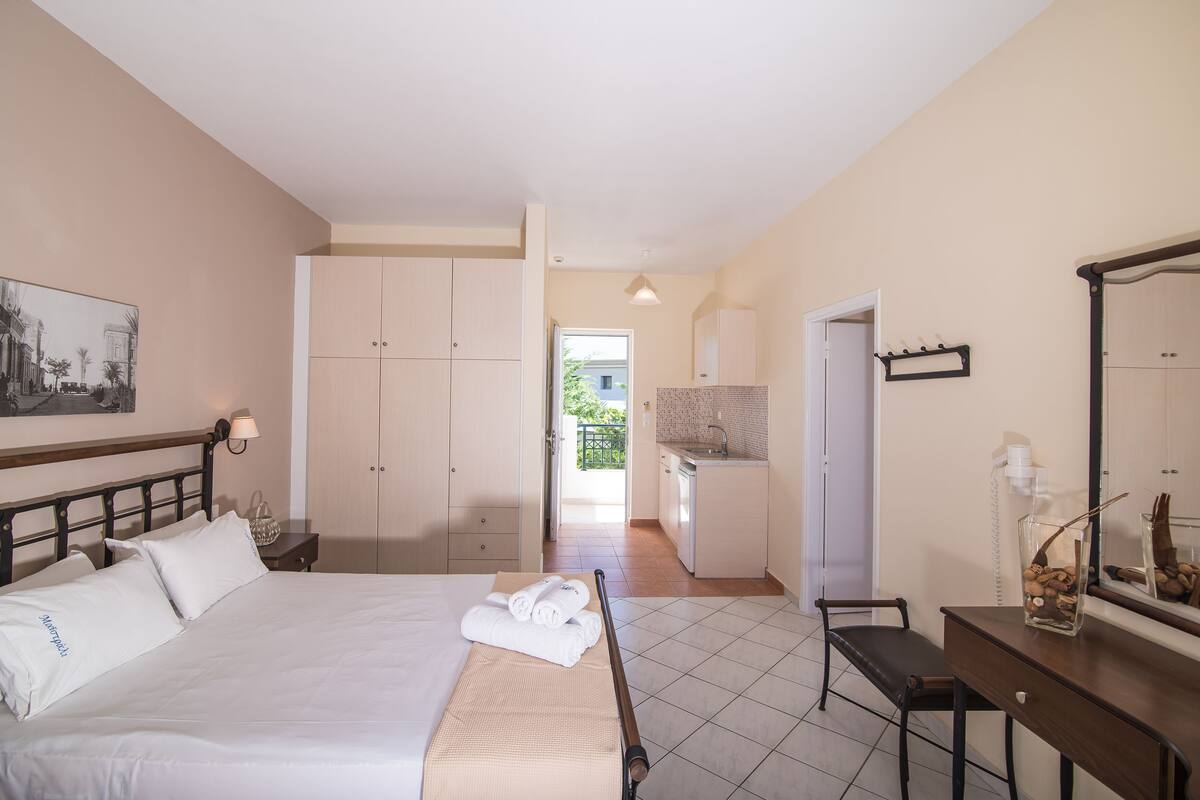 Een hotelkamer met een bed, een bureau, een badkamer en uitzicht op buiten.
