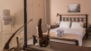 Une chambre d’hôtel bien rangée, avec un lit, des tables de chevet, une lampe et un tableau encadré au mur.