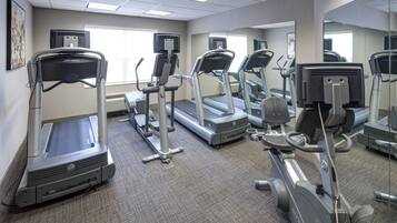 A gym with treadmills, elliptical machines, and stationary bikes.
