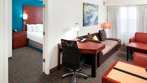 A hotel room with a bed, desk, chair, sofa, and a small table. - Residence Inn by Marriott Dothan (Dothan)