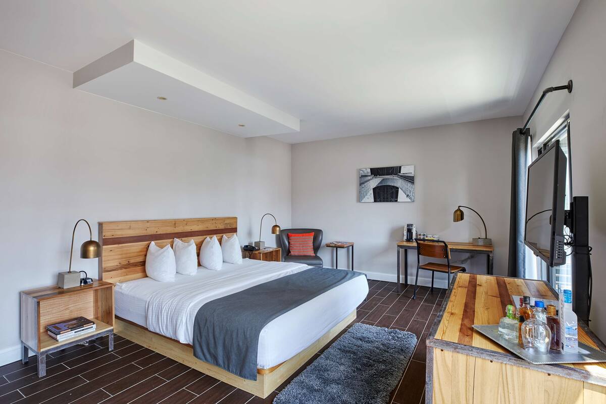 Een moderne hotelkamer met een groot bed, een bureau, een stoel en een televisie.