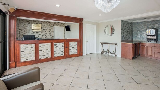 A spacious lobby with a reception desk, a chandelier, and a tiled floor. - Econo Lodge Lake Charles University Area (Lake Charles)