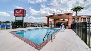 A hotel with a swimming pool, a covered patio, and a sign for EconoLodge. - Econo Lodge Lake Charles University Area (Lake Charles)