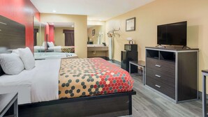 A hotel room with a bed, a desk, a TV, and a wardrobe. - Econo Lodge Lake Charles University Area (Lake Charles)