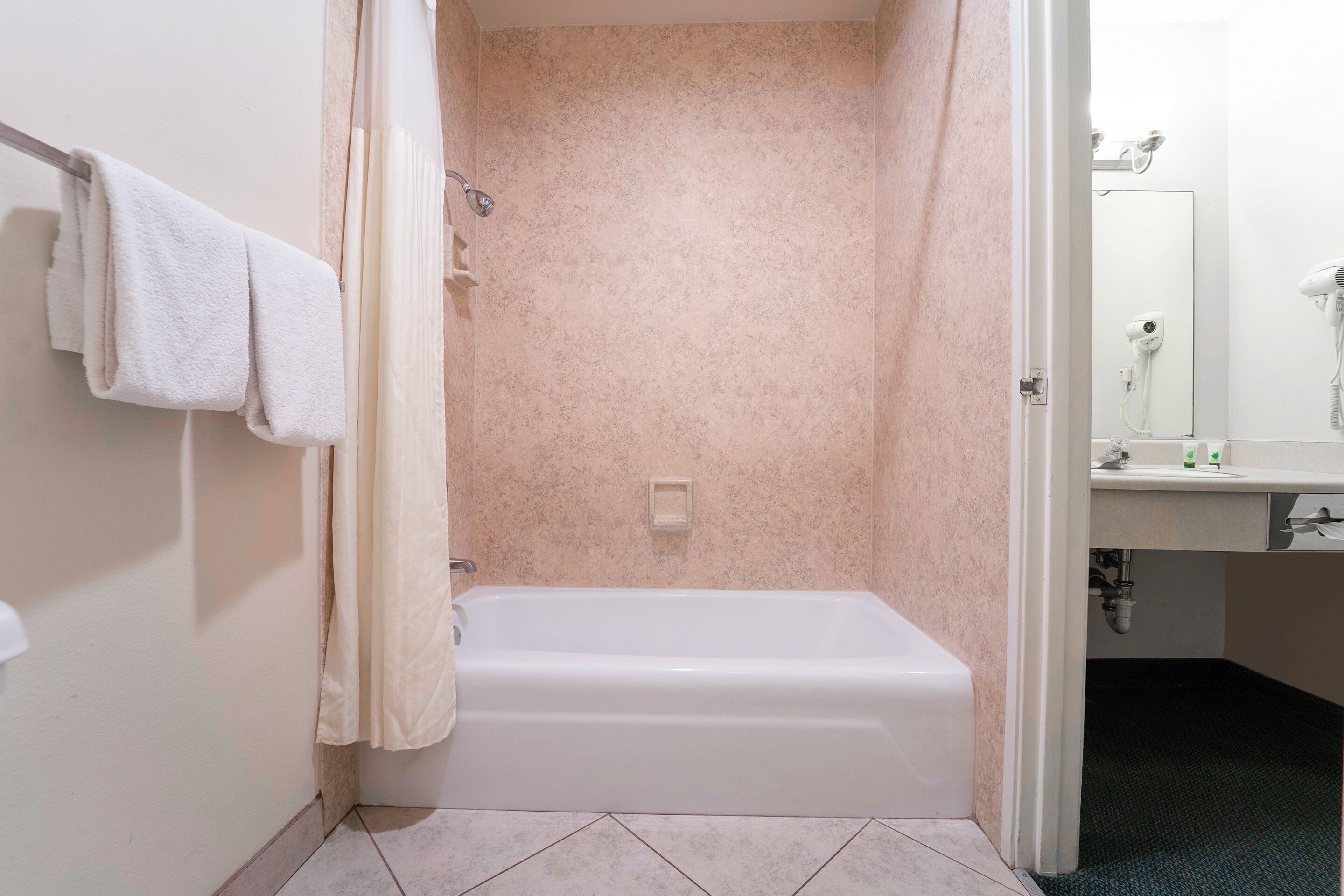 Une salle de bain avec une baignoire, une douche et un lavabo avec un miroir.