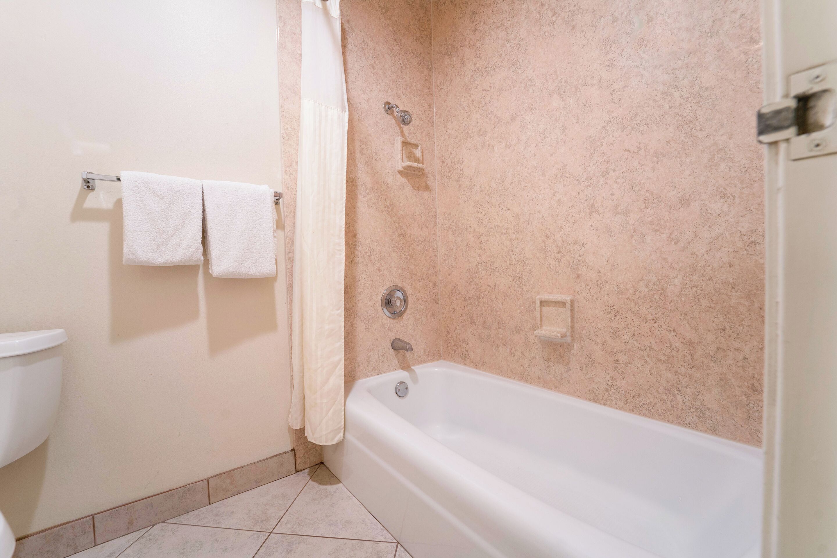 A bathroom with a bathtub, a toilet, and a towel rack.