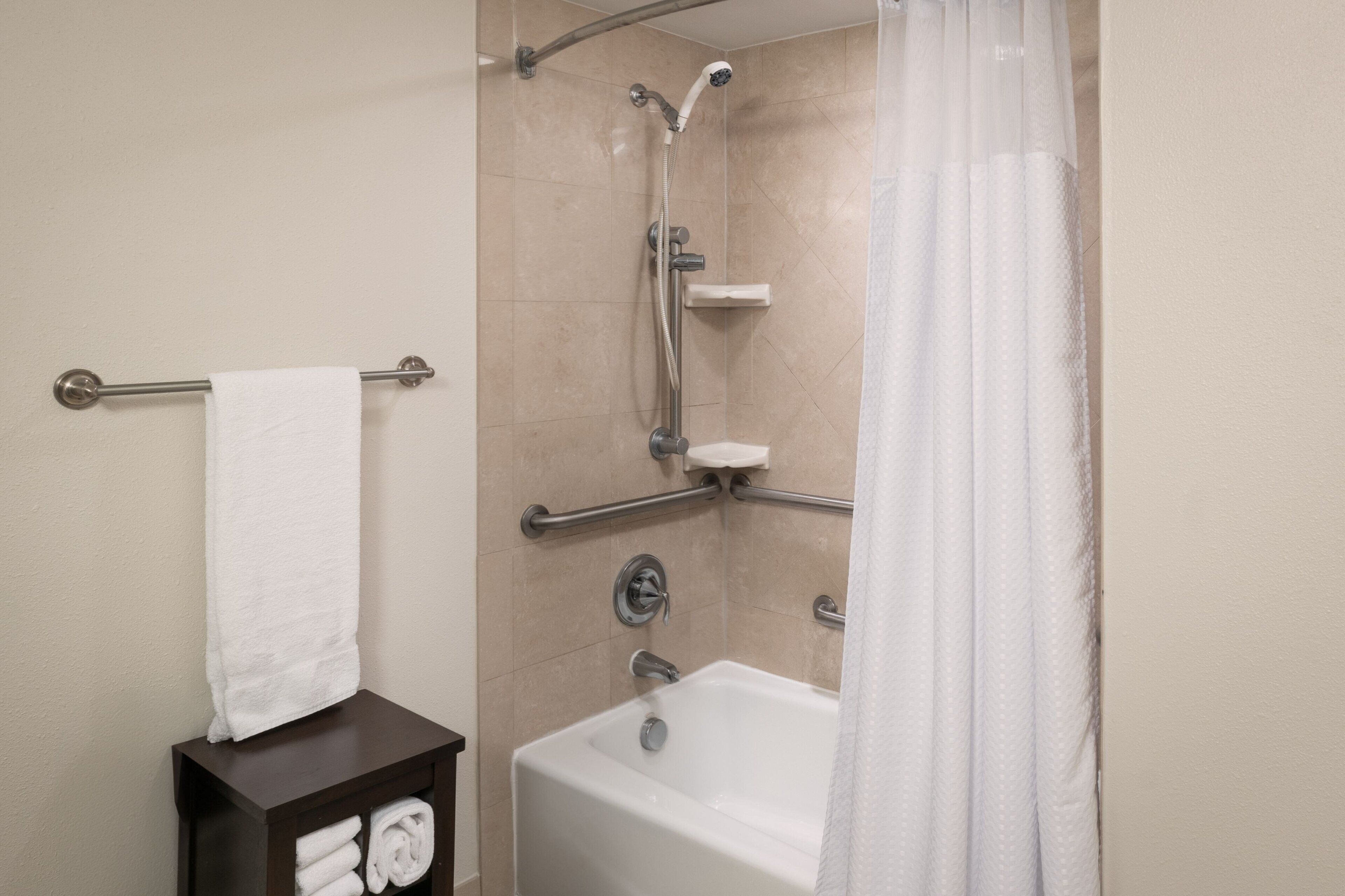 Une salle de bain avec une baignoire, une douche et un porte-serviettes.