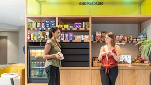 Un magasin de vente au détail moderne, doté d’étagères en bois où sont présentés divers produits alimentaires, d’un réfrigérateur-vitrine et d’une enseigne indiquant « Supermarché ».