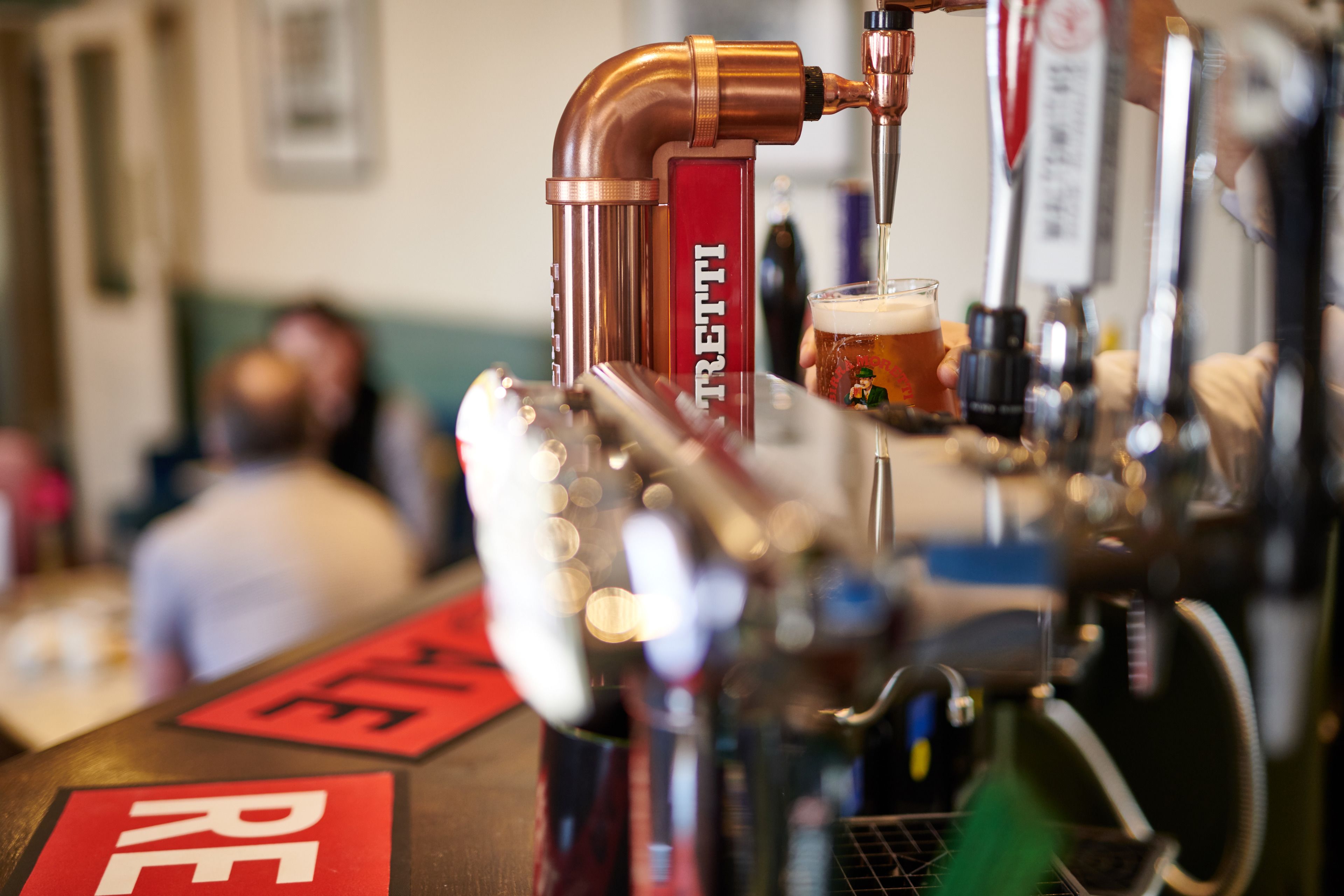 A bar area with a beer tap labeled "TRETTI" and a glass of beer.