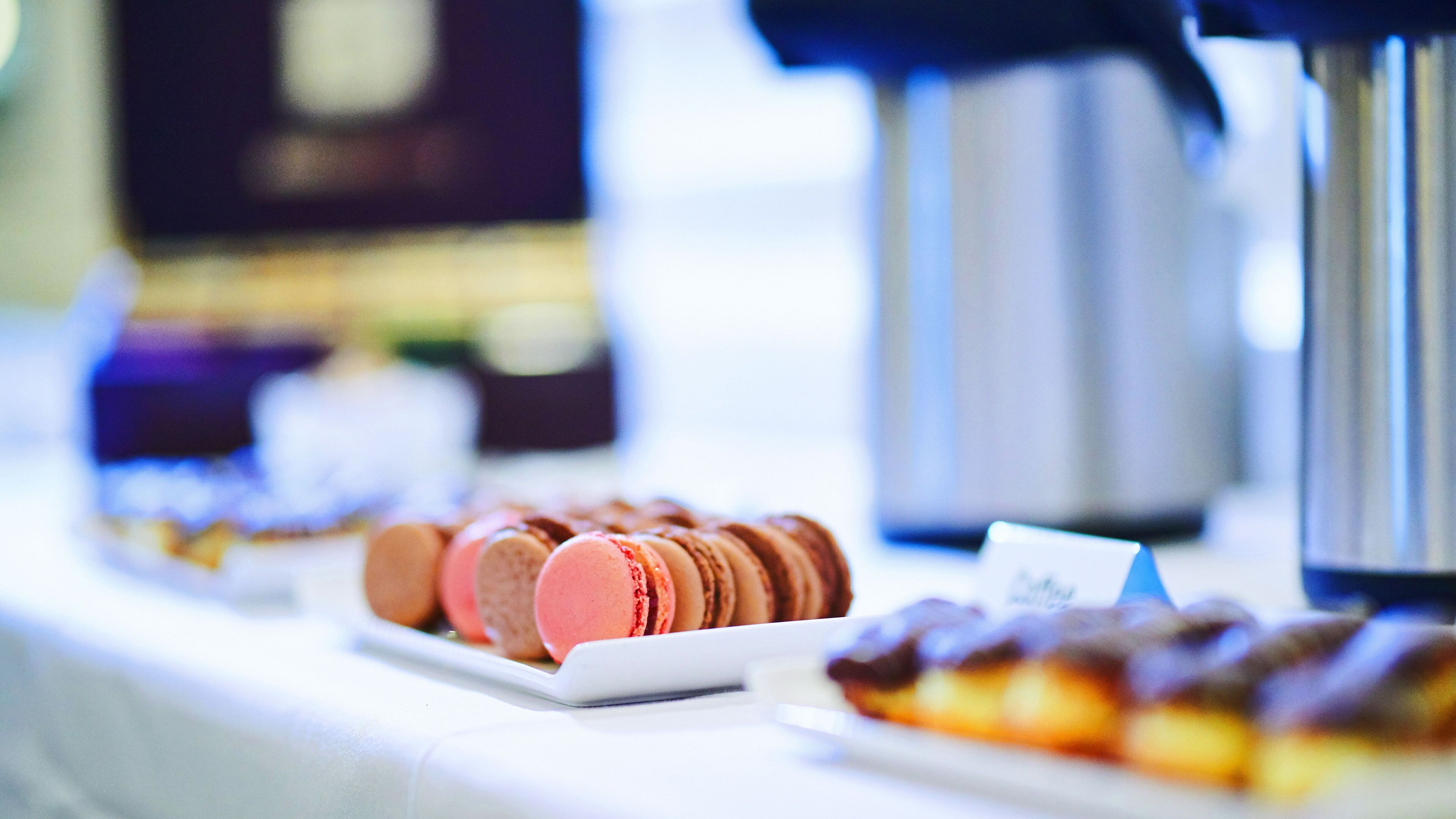 A buffet table with various desserts including macarons and pastries.