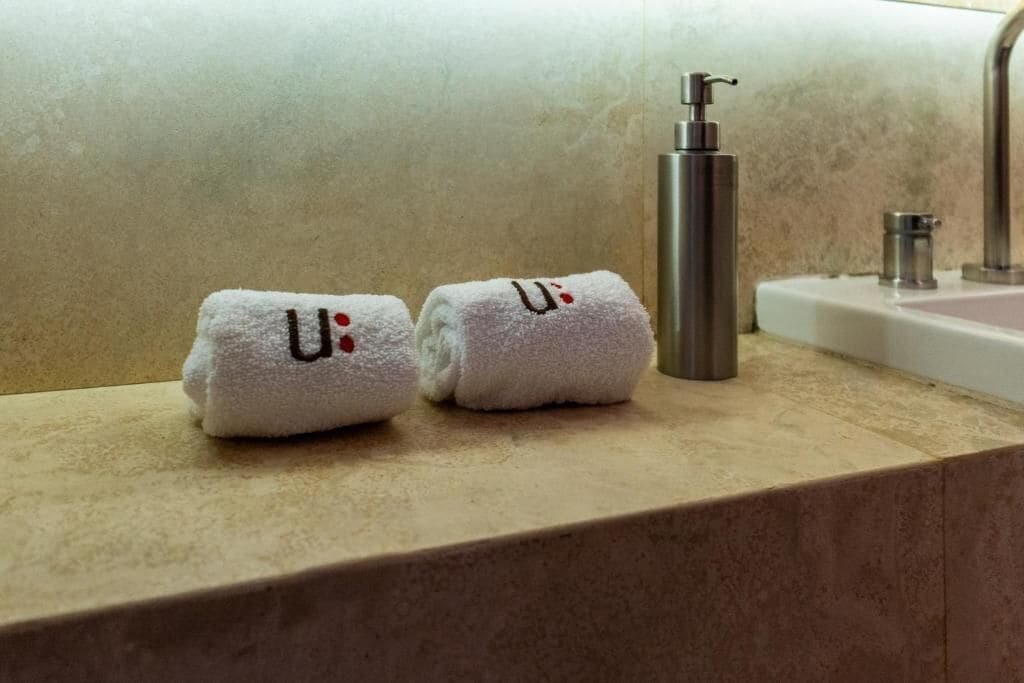 To håndklæder med 'U' og 'U' på en badeværelsesbordplade.