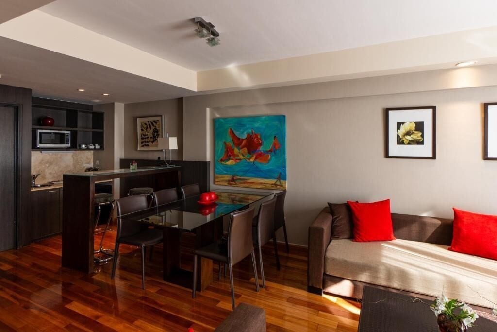 A modern living space with a dining area, kitchen, and seating area.