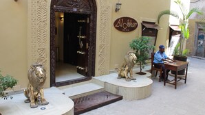 Una entrada de edificio con puertas ornamentales y un letrero que dice "Al Joham".