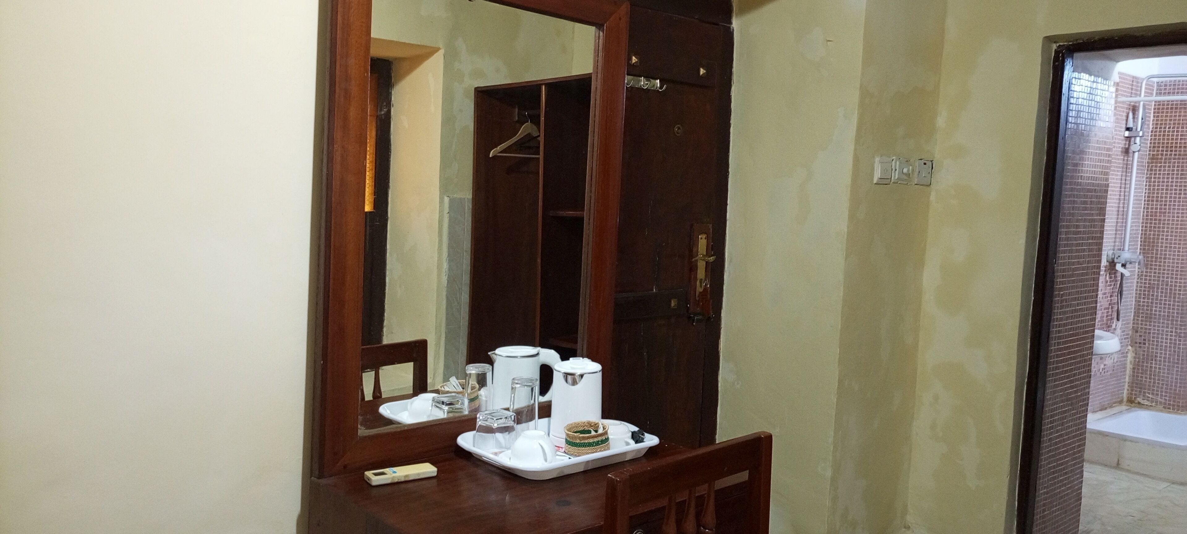 A bathroom with a shower, a toilet, and a sink. There is a mirror above the sink, and a towel rack is visible in the background.