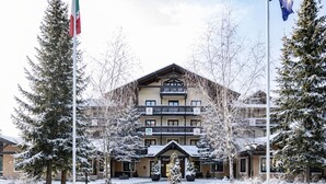Un hotel de varios pisos con una entrada cubierta de nieve y un letrero de estación de esquí.