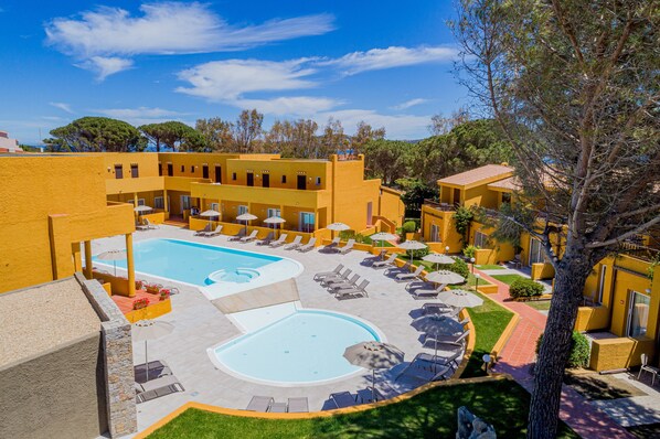 A hotel with a swimming pool, sun loungers, and a courtyard. - Blu Hotel Laconia Village (Arzachena)
