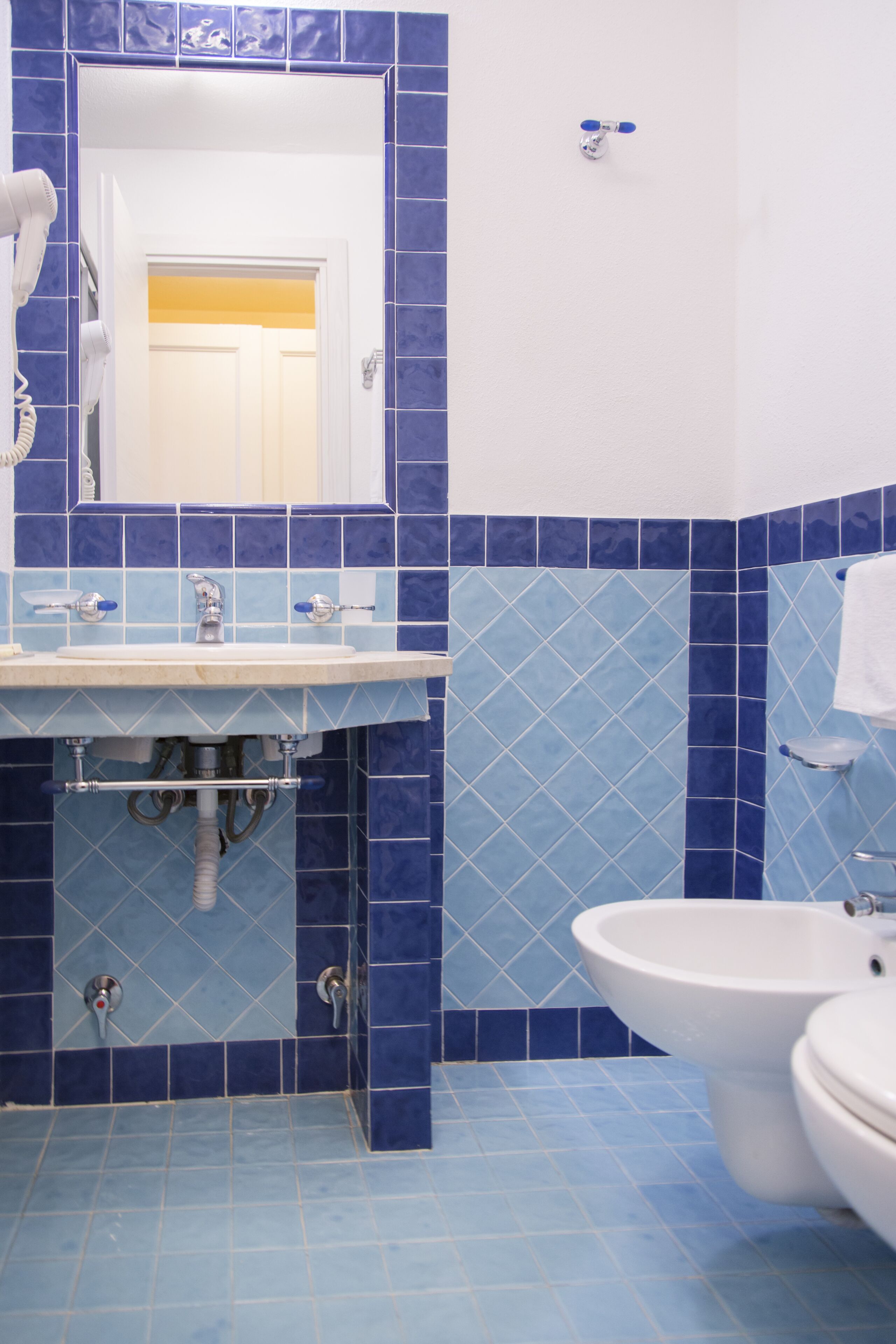 A bathroom with a sink, mirror, and toilet.