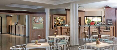 A modern bar area with white bar stools and a variety of bottles.