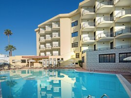 Una piscina al aire libre, tumbonas