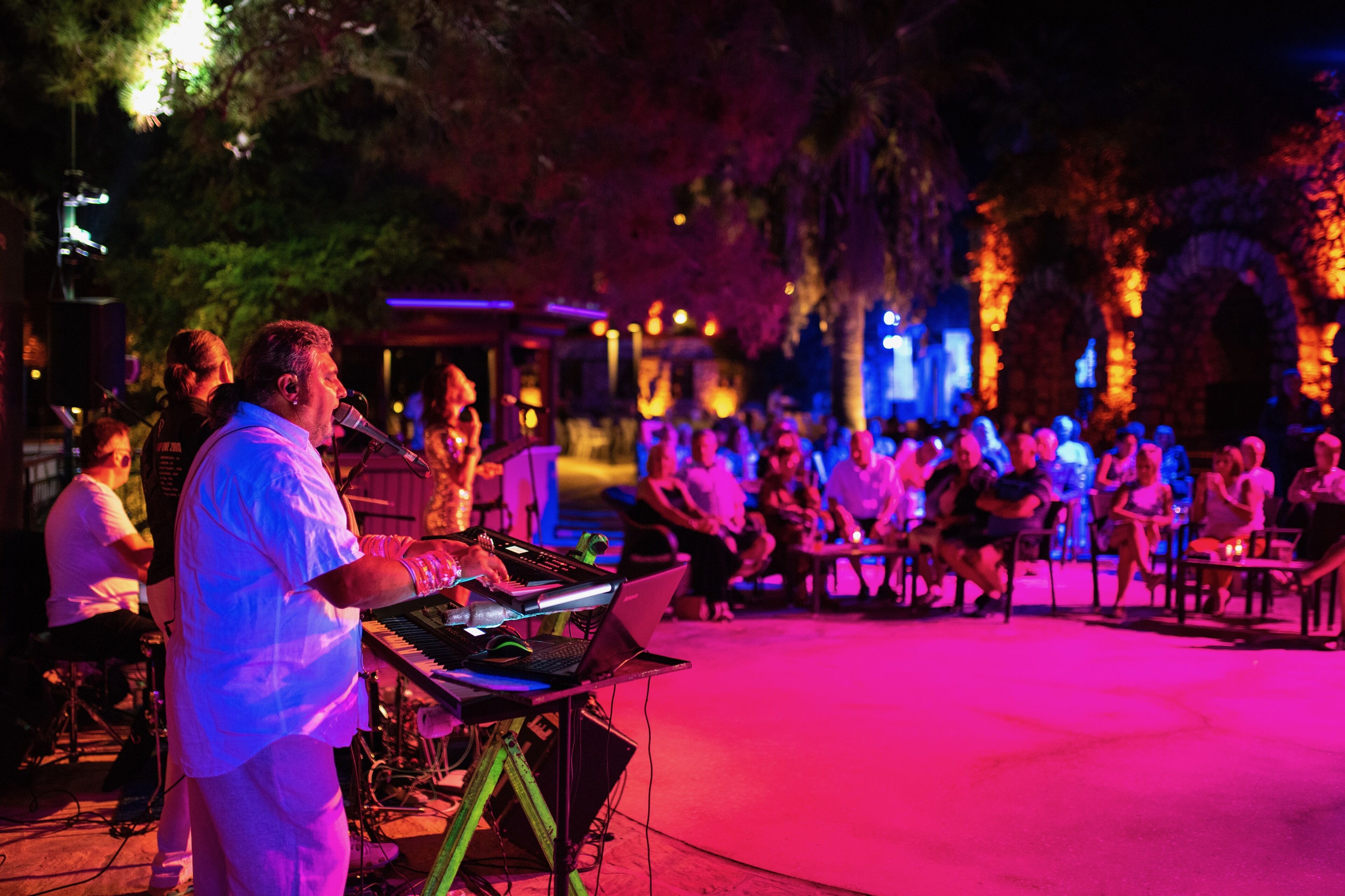 An outdoor event with a stage and seated audience.