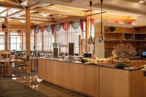 A restaurant with wooden beams, a buffet counter, and a seating area with tables and chairs. - Blu Senales Active & Family Resort (Senales)