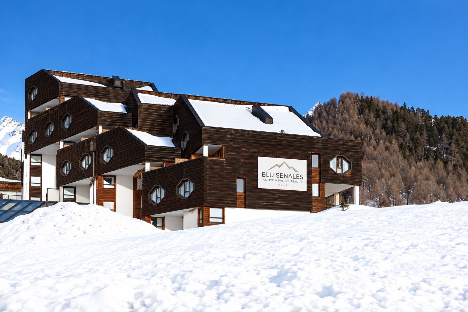 Un edificio moderno de varios pisos con un letrero que indica Blu Senales Active & Family Resort.
