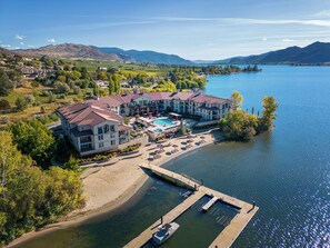 Un gran hotel con piscina, muelle y vistas al lago y a las montañas.