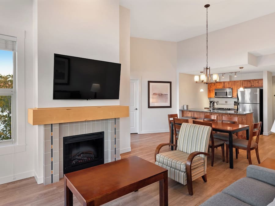 Una sala moderna con chimenea, comedor y cocina.