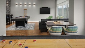 Ein modernes Wohnzimmer mit Poolbillard, einer Couch, einem Couchtisch und einer Billardtisch.