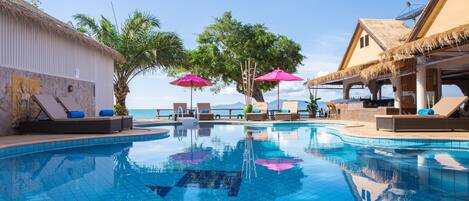 Una piscina al aire libre, sombrillas