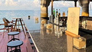A bar area with a view of the sea, wooden furniture, and a sign offering a 20% discount. - Adarin Beach Resort (Koh Samui)
