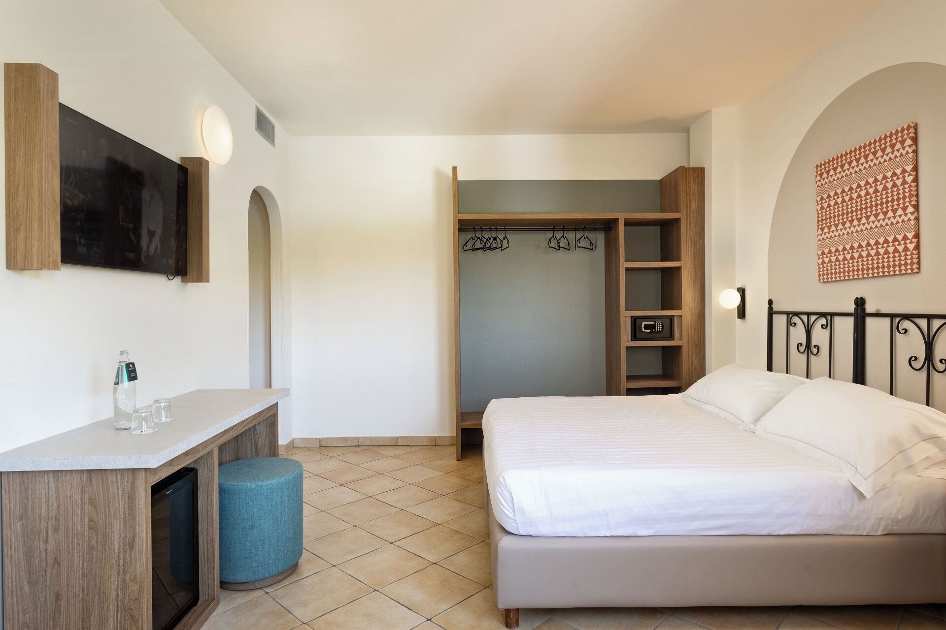 Ein Schlafzimmer mit Bett, Schreibtisch, Stuhl, Kleiderschrank und Bad.