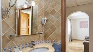 Une salle de bain équipée d’un lavabo, d’un miroir, d’un porte-serviettes et d’un sèche-cheveux.