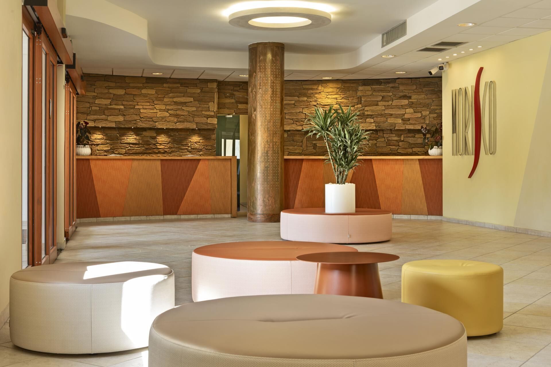 A lobby with a stone wall, a reception desk, and several seating areas.