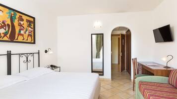 Une chambre d’hôtel avec un lit, un bureau, une chaise, une télévision et un tableau au mur.
