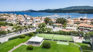 A coastal town with a marina, residential buildings, and a sports field.