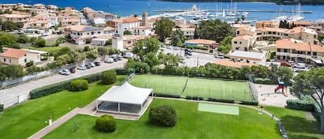 A coastal town with a marina, residential buildings, and a sports field.