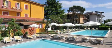 2 kolam renang outdoor, dengan payung kolam renang dan kursi berjemur