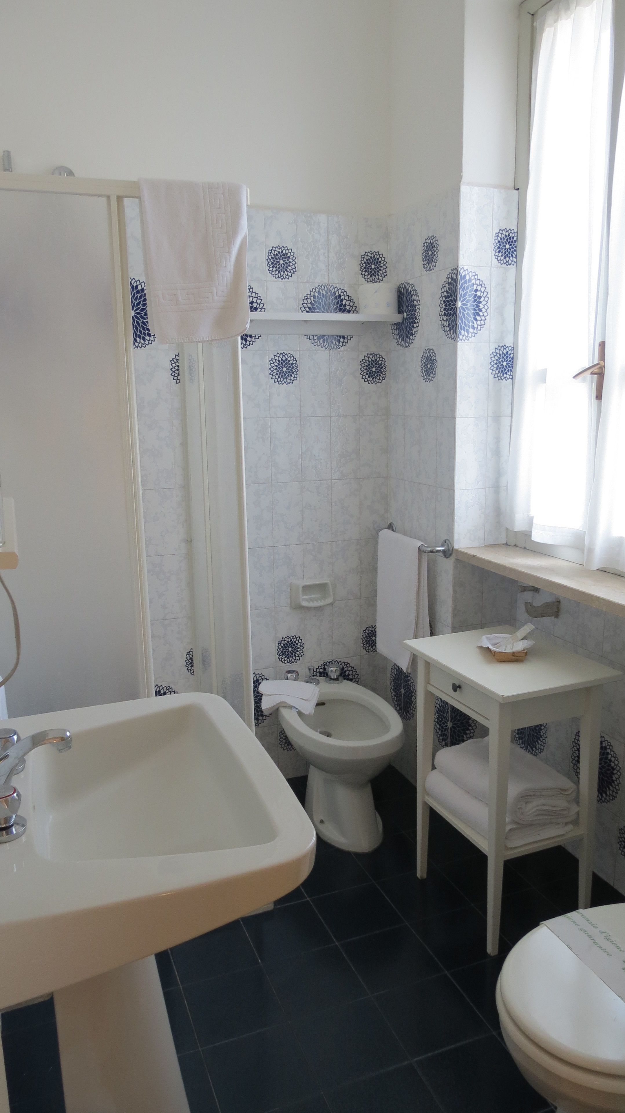 A bathroom with a sink, toilet, and bidet.