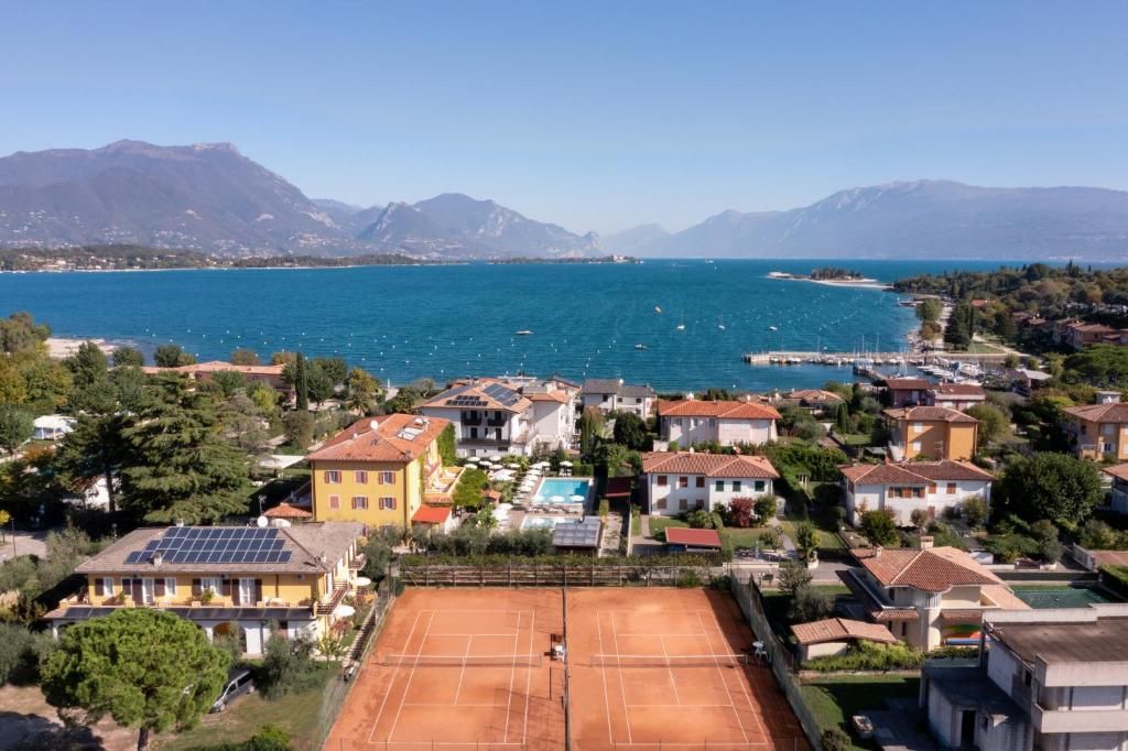 Un quartier résidentiel avec des maisons, un court de tennis et un plan d’eau où l’on peut faire du bateau.