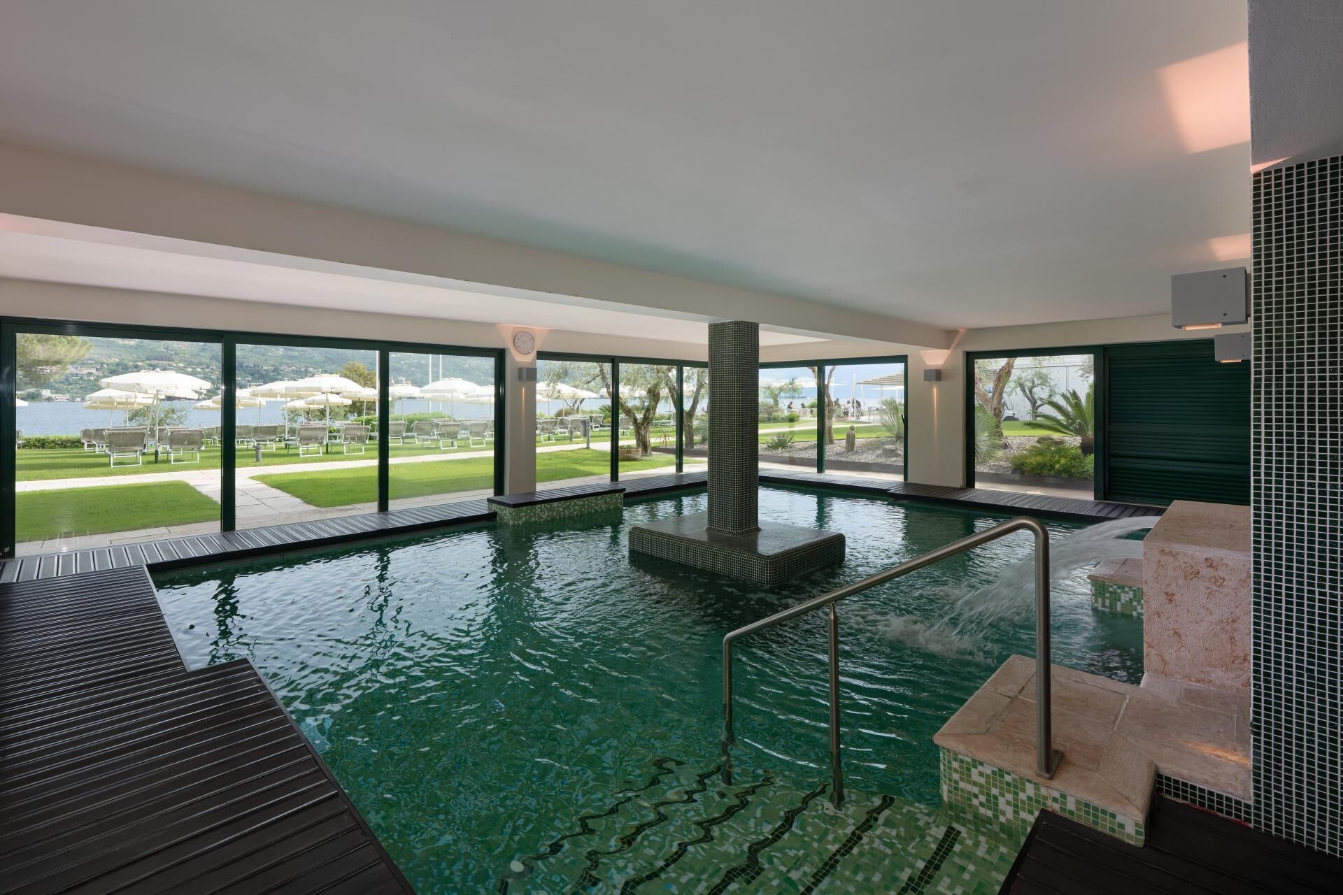 Piscina interior com vista clara para área ajardinada externa.