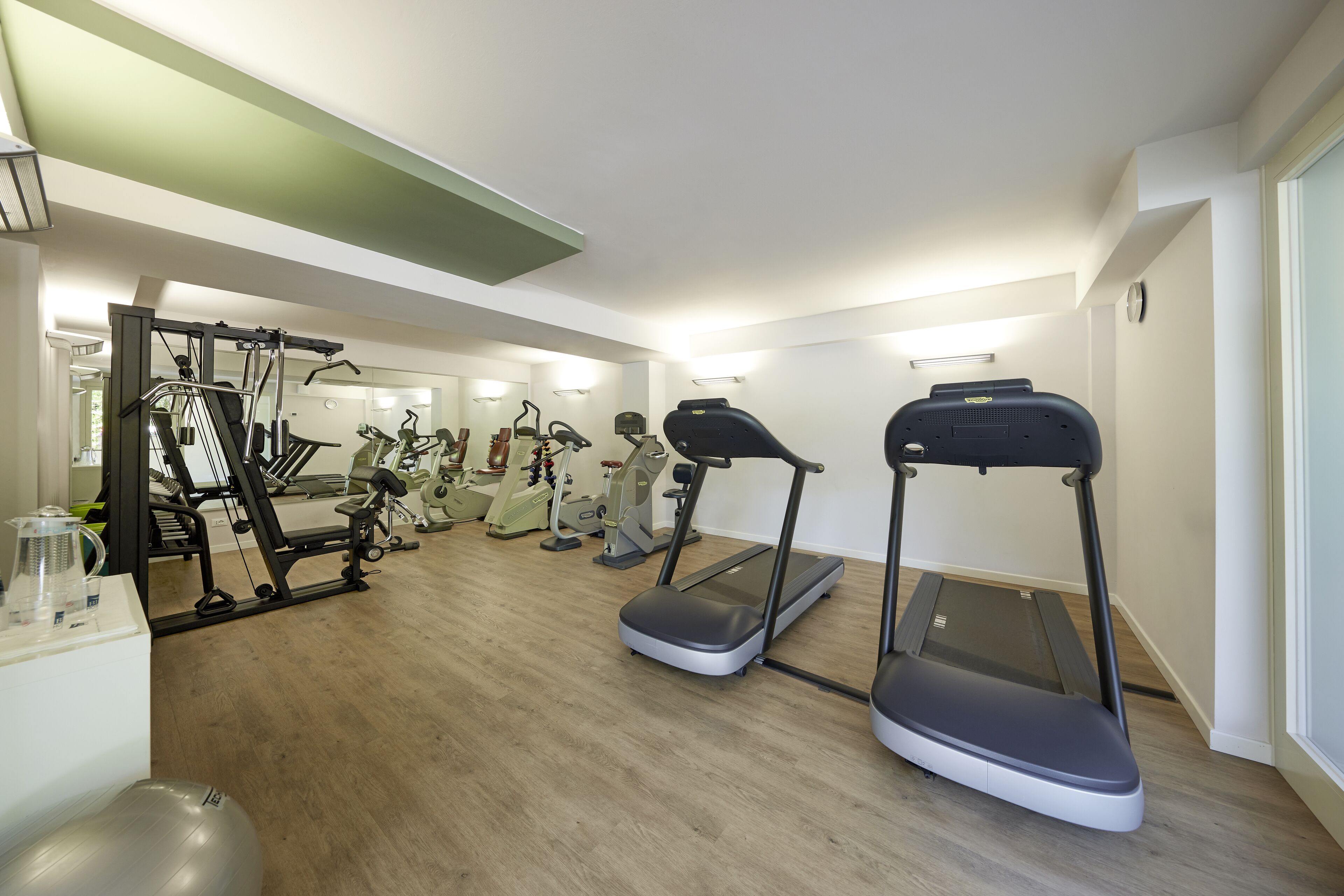 Een sportschool met loopbanden, elliptische trainers en gewichten.