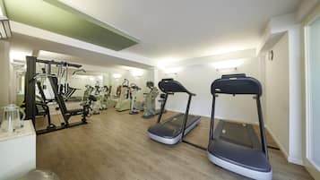 Ein Fitnessstudio mit Laufbändern, Crosstrainern und Gewichten.