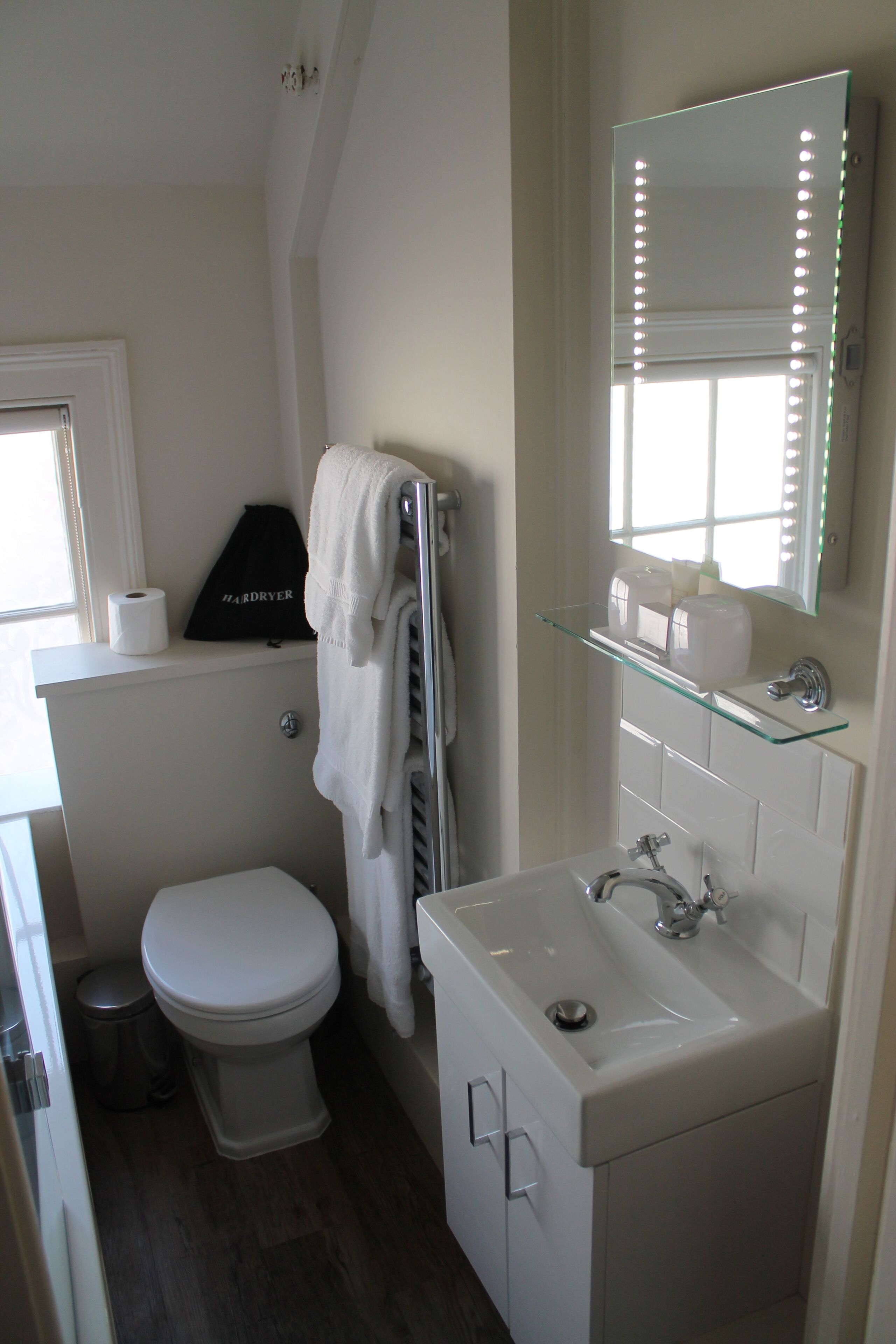 A bathroom with a toilet, sink, and mirror.