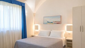 A hotel room with a bed, nightstands, a painting, and a wardrobe. - Color Dolmen Family Village (Minervino di Lecce)