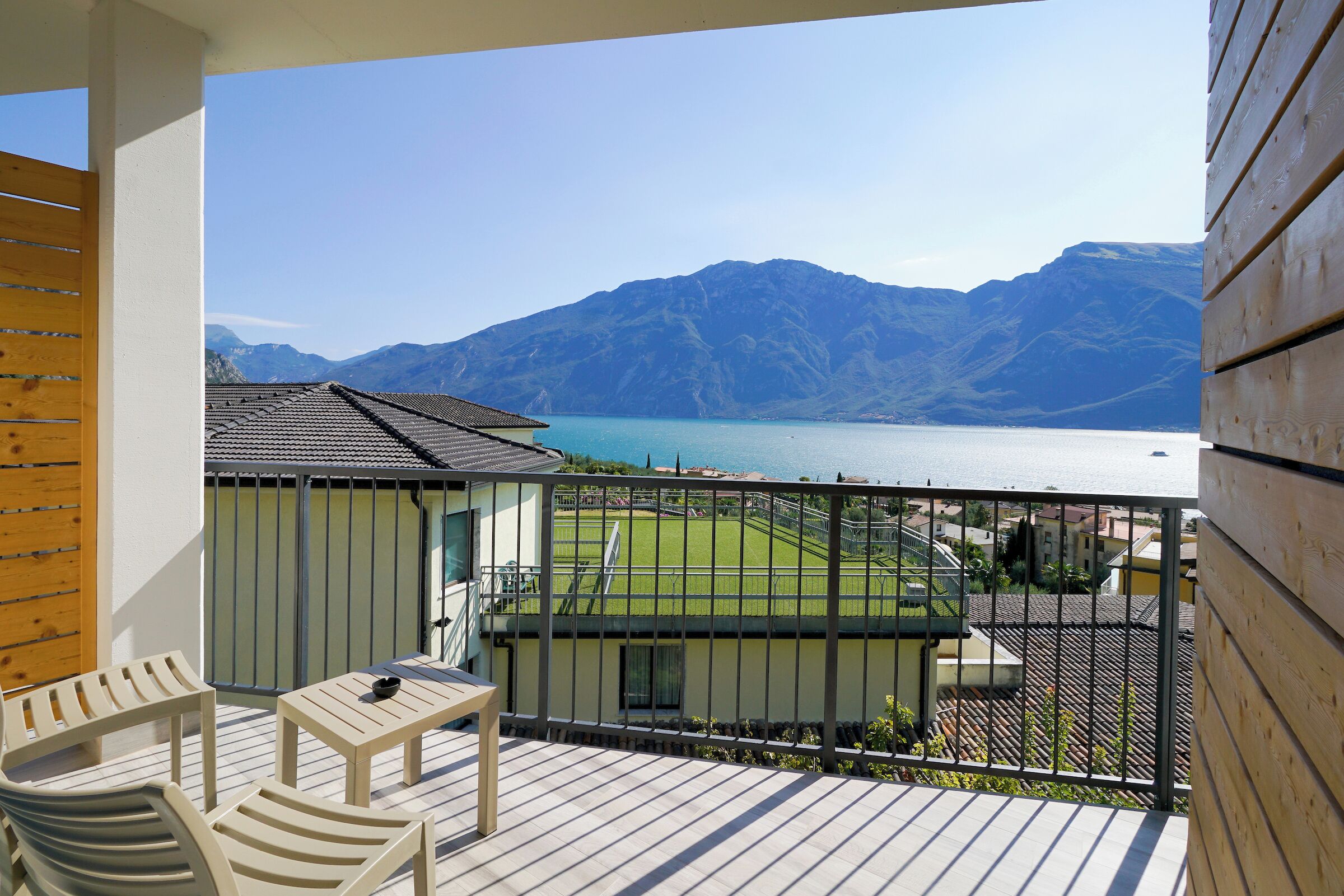 A balcony with a view of mountains and a lake.