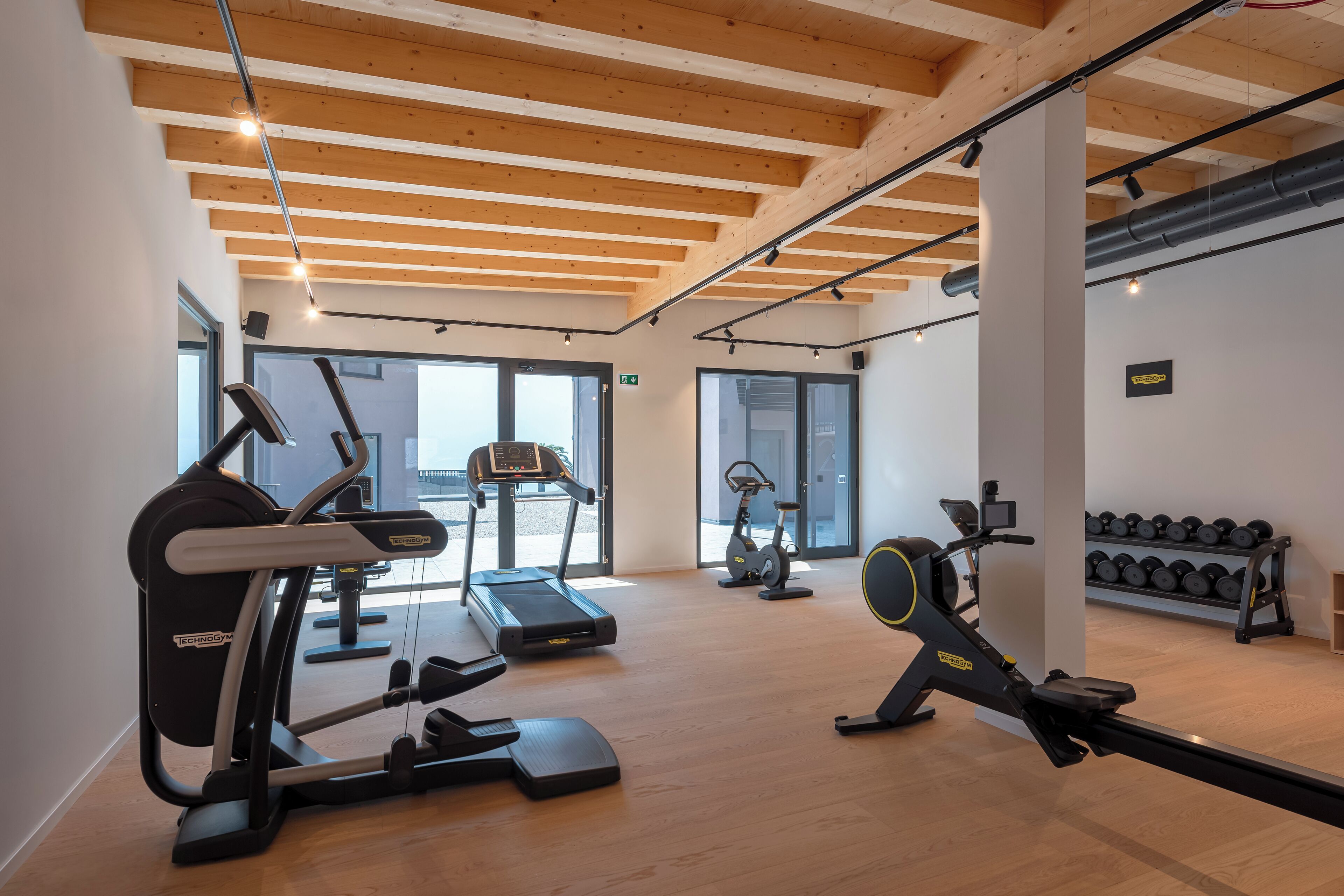 Ein Fitnessraum mit Laufbändern, Crosstrainern und Rudergeräten.